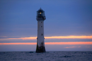 Lighthouse with base submerged in ocean